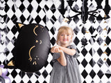 Child holding black cat head balloon.