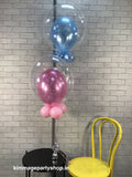 Pink and blue printed balloons inside clear balloons, placed on a small black table.
