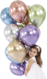 Smiling little girl holding different coloured shiny balloons.