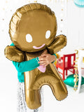 Child hugging gingerbread man balloon.
