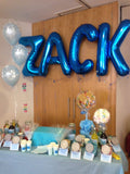 Large helium filled blue letter balloons.