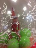 Toy elf inside clear balloon.