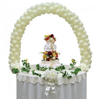 Ivory coloured balloon arch over a table.