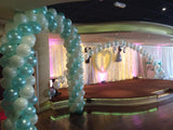 Large wedding balloon arch beside a stage.
